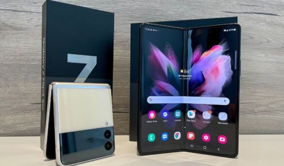 Foldable smartphone displayed open and closed next to its retail box on a desk